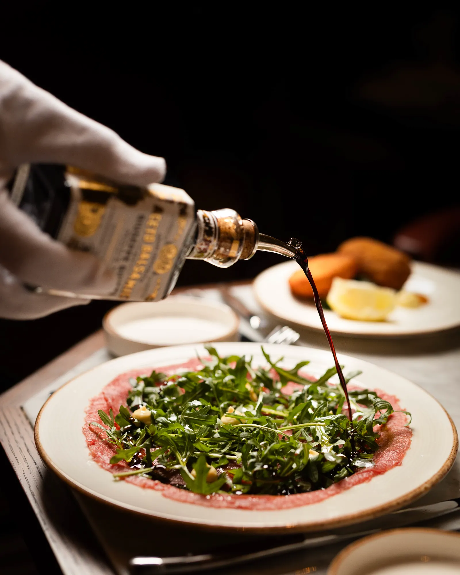 Balsamic is drizzled over the Rundscarpaccio with rocket
