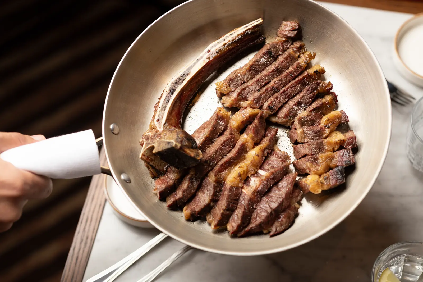 Sliced steak on the bone in a pan