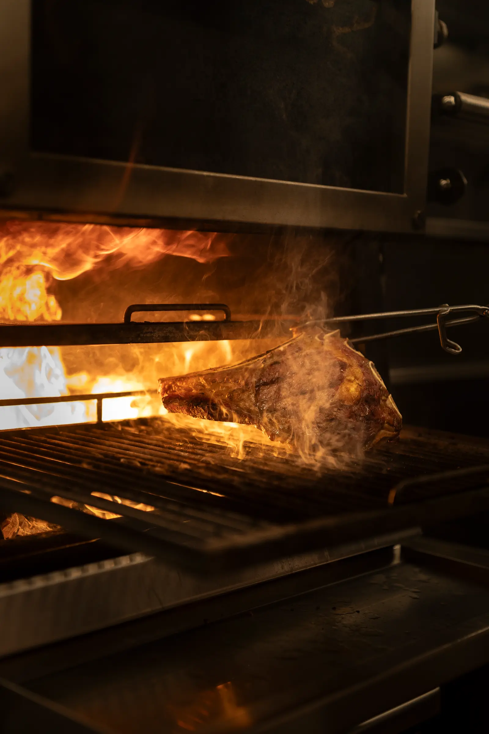 De la viande sur le gril au charbon de bois, entre les flammes